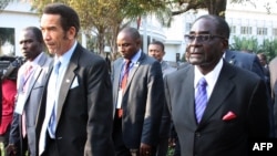 FILE: Botswana President Ian Khama (L) walks alongside Zimbabwe President Robert Mugabe (R) during a lunch break at the SADC summit in Maputo, June 15, 2013. 