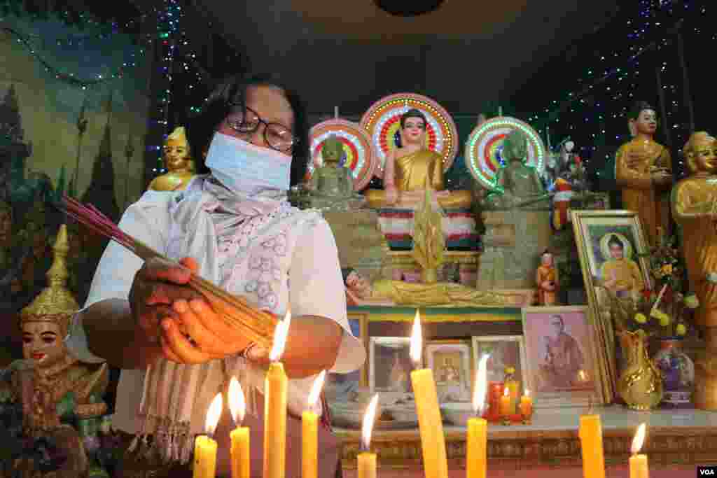 ស្រ្តី​ម្នាក់​កំពុង​អុជ​ធូប​ក្នុង​វត្ត​និរោធ​រង្សី រាជធានី​ភ្នំពេញ ក្នុង​ពេល​​ប្រារព្ធ​ពិធី​បុណ្យ​ចូល​ឆ្នាំ​ខ្មែរ​ថ្ងៃទី​២ នៅ​ថ្ងៃ​ទី​១៤ ខែមេសា ឆ្នាំ​២០២០។ (កាន់ វិច្ឆិកា/VOA)​​