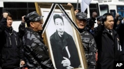 2010年3月26日，前韩国陆军司令情报特遣队士兵举着独立斗士安重根的遗像在他被日本处死一百周年之际在日本驻首尔大使馆前示威。