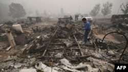 2020年9月12日俄勒冈州埃斯塔卡达居民马塞利诺·马塞达在山火烧毁的他的活动住房残迹寻找东西。