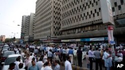 People evacuate buildings and gather on road after an earthquake was felt in Karachi, Pakistan, April 16, 2013.