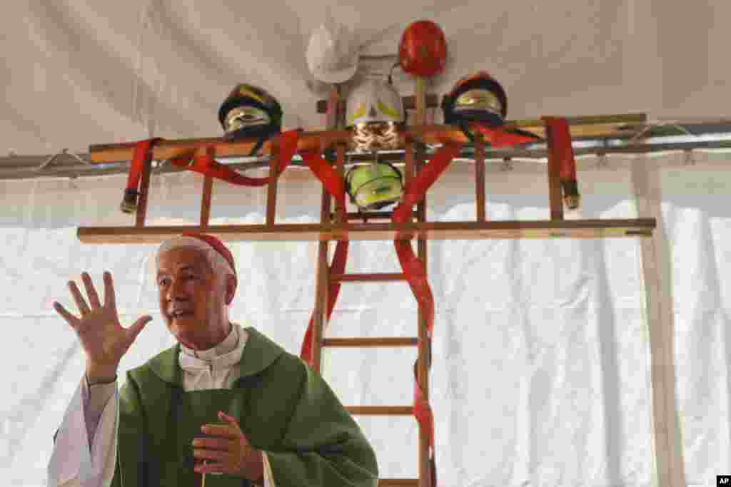 A cross made with ladders and firefighter helmets is placed inside a tent during a Mass celebrated by Bishop Giovanni D&#39;Ercole, in Arquata Del Tronto, near Amatrice, central Italy. The tent was set up as a temporary shelter for the earthquake survivors.