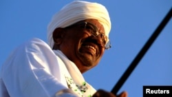 Sudanese President Omar al-Bashir surveys a rally with Sufi supporters in Hajj Yusuf at Khartoum district, Dec. 27, 2014. 