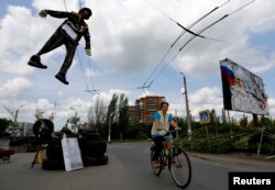 在乌克兰城市斯拉维扬斯克，亲俄分子在他们建立的路卡上吊着乌克兰士兵的人像。（2014年5月13日）