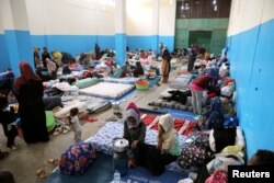 FILE - Migrants are seen at a detention center in Zawiya, west of Tripoli, Libya, April 26, 2019.