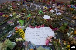 FILE - Notes and flowers form a memorial in Charlottesville, Va., Aug. 18, 2017, at the site where Heather Heyer was killed. Heyer was struck by a car while protesting a white nationalist rally on Aug. 12.