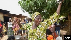 Une des femmes de la communauté Baoulé fait des gestes en préparant de la nourriture lors des célébrations dans le village d'Assounvoue, en Côte d'Ivoire, le 1er avril 2018.