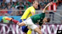 El sueco Andreas Granqvist y el mexicano Javier Hernandez, (frente) durante el partido por que México perdió 3-0 frente a Suecia.