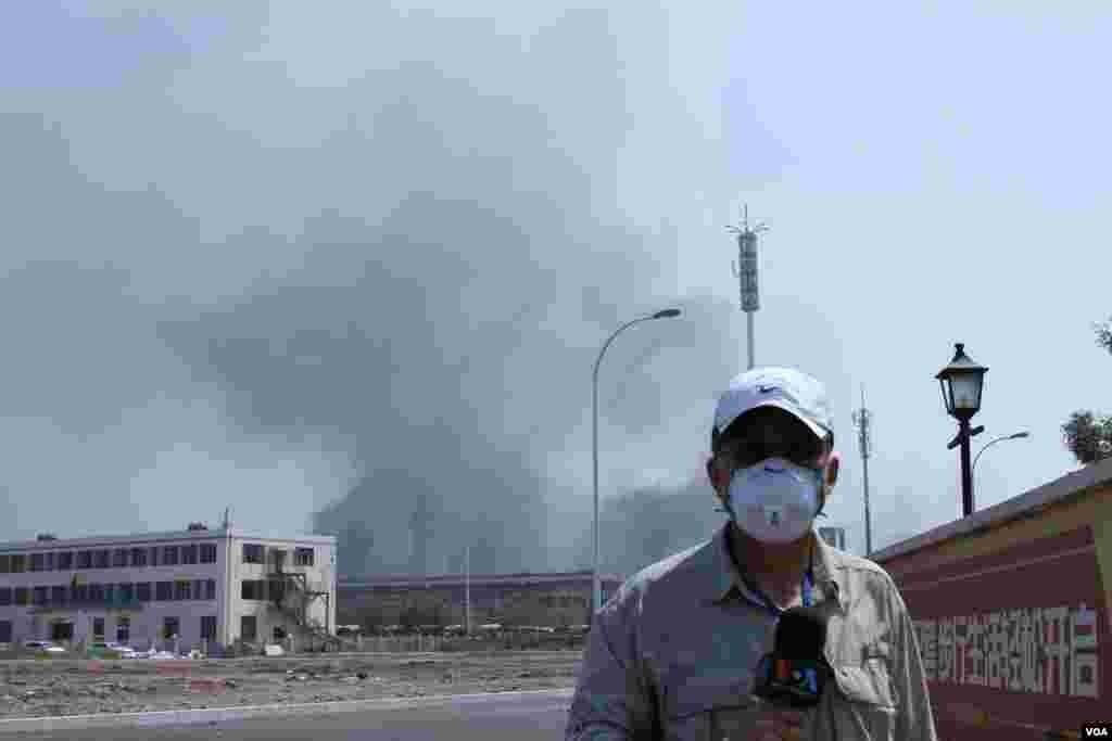 天津爆炸事故现场，核心爆炸区周围多座居民楼窗户被震碎，高速公路桥梁受损，多辆大货车被炸翻，小汽车起火或被砸，多名当地居民仍逗留在事故现场。（美国之音记者东方拍摄）