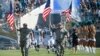 Military personnel lead the Jacksonville Jaguars players onto the field during player introductions before an NFL football game against the Miami Dolphins in Jacksonville, Florida, Sept. 20, 2015.