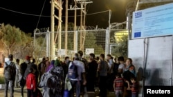 Refugiés et migrants attendent devant une porte fermée au camp de Moria migrant, sur l'île de Lesbos, Grèce,le 19 septembre 2016. 