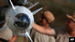 俄罗斯的军事团队检查其飞机所链接的导弹。（2015年10月6日）