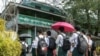 Students wait outside a school entrance in Sittwe, capital of western Rakhine State on June 1, 2021. - Schools in Myanmar opened on June 1 for the first time since the military seized power, but teachers and students are set to defy the junta's calls for 