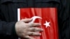 FILE - A supporter of Gulen movement holds a Turkey's national flag during a protest outside the Kanalturk and Bugun TV building in Istanbul, Turkey, Oct. 28, 2015. 