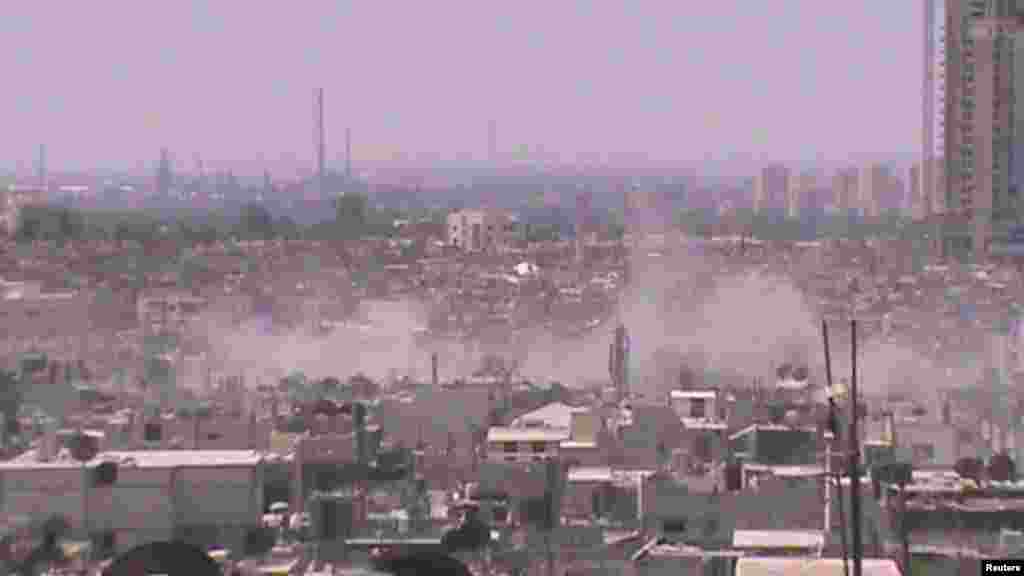 Asap mengepul dari kawasan Juret al-Shayah di kota Homs, Suriah (11/7).