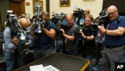 Photojournalists photograph four pages of the Mueller Report laid on the witness table in the House Intelligence Committee hearing room on Capitol Hill, April 18, 2019.