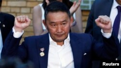 Presidential candidate Khaltmaa Battulga gestures outside a polling station after casting his ballot in Ulaanbaatar, Mongolia, June 26, 2017. Battulga won the presidential runoff election Saturday.