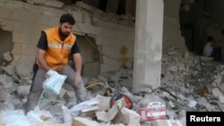 یکی از اعضای صلیب سرخ جهانی در حال بررسی مواد و لوازم پزشکی باقی مانده در ساختمانی که هدف حمله هوایی قرار گرفته است - آرشیو