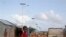 A Somali child stands under the solar powered lights at a refugee camp that were installed to help combat the rampant rapes that were occurring at night, in Mogadishu, Somalia, July 17, 2013.