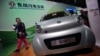 A visitor looks at an E30 EV, a small electric vehicle of Chinese state-owned automobile manufacturer Dongfeng Motor Co., at China International Industry Fair in Shanghai, Nov. 5, 2013. 