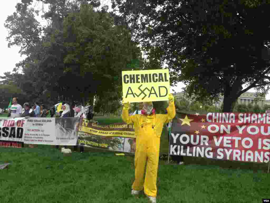 反对美国军事干预叙利亚的抗议人士向路过的行人与车辆展示抗议标语。