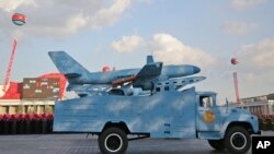 ລົດ​ບັນ​ທຸກ​ຂົນ​ສິ່ງ​ທີ່​ເບິ່ງ​ຄື​ວ່າ​ເປັນ​ໂດ​ຣນ​ຂອງ ເກົາຫຼີ​ເໜືອ ໃນ​ພິ​ທີ​ເດີນ​ສວນ​ສະ​ໜາມ.