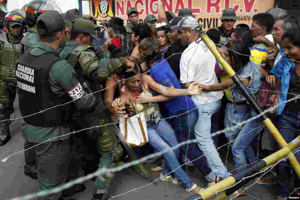 People clash with Venezuelan National Guards as they try to cross the border to Colombia over the Francisco de Paula Santander international bridge in Urena, Venezuela, Dec. 18, 2016. 