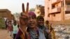 Sudanese protesters flash victory signs and shout slogans, as they march during a protest against the military council, in Khartoum, Sudan, June 27, 2019. 