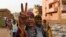 Sudanese protesters flash victory signs and shout slogans, as they march during a protest against the military council, in Khartoum, Sudan, June 27, 2019. 