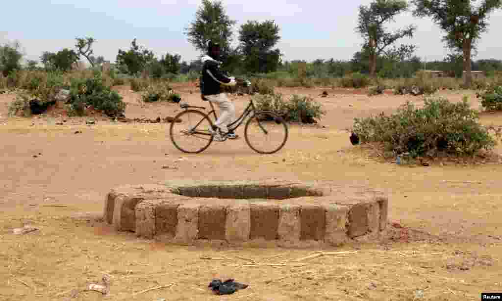 一个马里人2013年1月28日骑车经过萨瓦雷城镇的一口井。据人权观察联合国事务主任波洛皮恩说，被杀害的伊斯兰武装嫌疑分子的尸体被丢弃在这口井里。