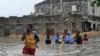 People evacuate their homes through waist-deep flood water in Mogadishu, May 20, 2018, after homes were inundated in Somalia's capital following heavy overnight rainfall. 