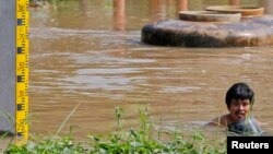 A man wades through flooded area in Ayutthaya province, Thailand, Oct. 2, 2013.
