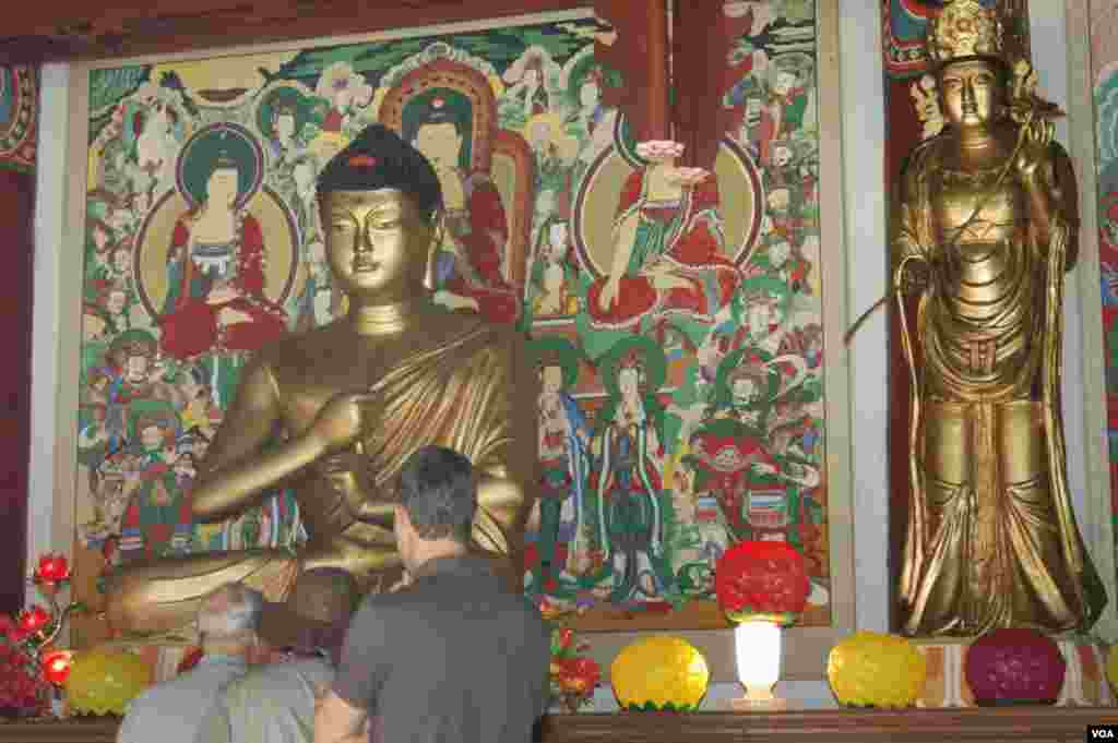 Turis-turis Amerika di dalam Gedung Taeung, yang hancur selama Perang Korea akibat pengeboman oleh AS, dibangun kembali pada 1976 dengan mempertahankan bangunan asli pada 1765. (VOA/Steve Herman) 