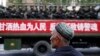 FILE - A Uighur man looks on as a truck carrying paramilitary policemen travel along a street during an anti-terrorism oath-taking rally in Urumqi, Xinjiang Uighur Autonomous Region.