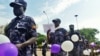 FILE - Ugandan Police hold balloons and signs condemning violence against women, Kampala, Uganda, Dec. 5, 2015.