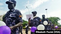 FILE - Ugandan Police hold balloons and signs condemning violence against women, Kampala, Uganda, Dec. 5, 2015.