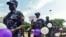 FILE - Ugandan Police hold balloons and signs condemning violence against women, Kampala, Uganda, Dec. 5, 2015.