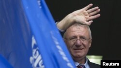 FILE - Serbian nationalist leader Vojislav Seselj waves to his supporters from a balcony of his Serbian Radical Party headquarters in Belgrade, Serbia, Nov. 12, 2014