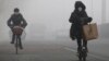 People ride amid the smog in Beijing, China, Feb. 14, 2017. 