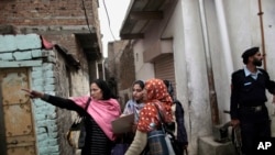 1월 30일 촬영된 사진에서 파키스탄 경찰이 소아마비 예방주사를 놓는 보건 요원들을 보호하고 있다.