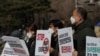 South Korean protesters hold signs during a rally to oppose the joint military exercises between South Korea and the United States near the presidential Blue House in Seoul, South Korea, March 8, 2021.