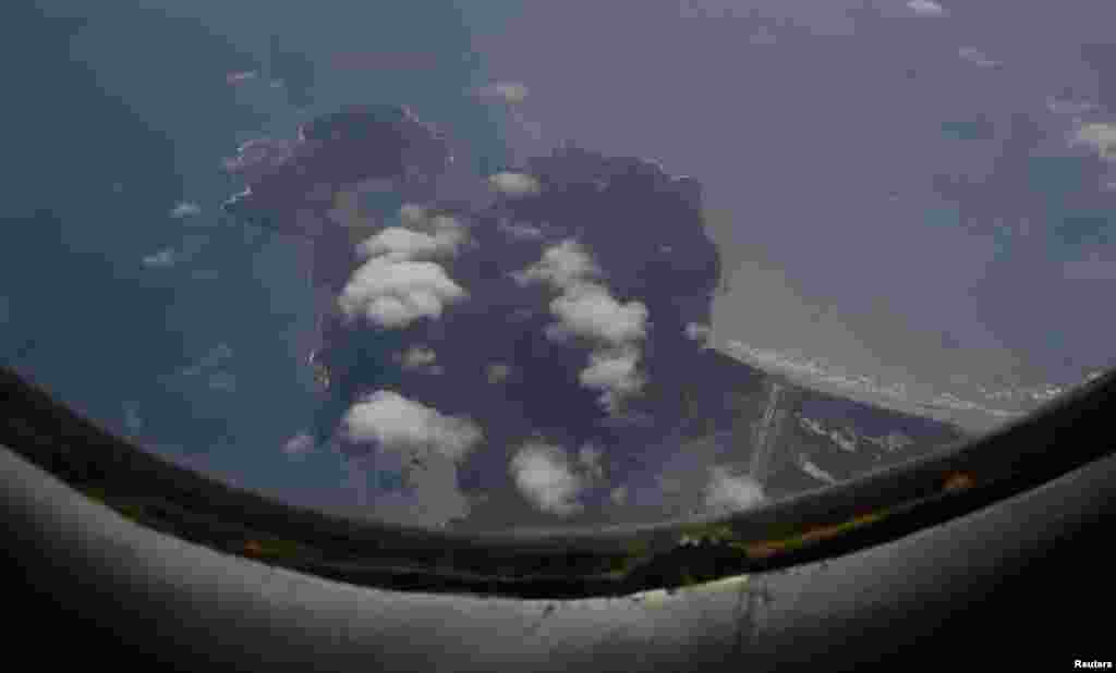 Pesawat Angkatan Udara Vietnam AN-26 terbang di atas pulau Con Dao dalam misi pencarian pesawat Malaysia Airlines penerbangan MH370 yang hilang, 12 Maret 2014.