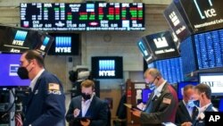 FILE - Traders work on the floor of the New York Stock Exchange, May 18, 2021. Investors remain focused on the possibility for more inflation later this year. (NYSE photo)