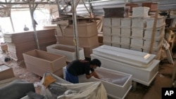 آماده کردن تابوت با رعایت پروتکل‌های کرونا برای جان‌باختگان از این ویروس مرگبار - جاکارتا، اندونزی - ۱۳ ژوئیه ۲۰۲۱