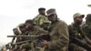 M23 rebels sit at the back of a pick-up truck captured a week before and formerly used by the Armed Forces of the Democratic Republic of Congo, as they carry supplies through Bunagana, July 15, 2012. 