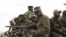 M23 rebels sit at the back of a pick-up truck captured a week before and formerly used by the Armed Forces of the Democratic Republic of Congo, as they carry supplies through Bunagana, July 15, 2012. 