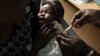 FILE - A mother holds her baby as she receives a malaria vaccination at the Walter Reed Project Research Center in Kenya, Oct. 30, 2009. 