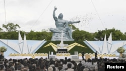 日本长崎的和平公园纪念原子弹轰炸72周年，鸽子在和平雕塑上空飞过（2017年8月9日）