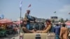 Taliban fighters on a pick-up truck move around a market area bustling with local shoppers, in Kabul, Afghanistan, Aug. 17, 2021, following the insurgent group's takeover of the country.