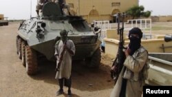 Fighters from the Al Qaeda-linked Islamist group MUJWA stand guard in Gao, northern Mali, August 7, 2012.